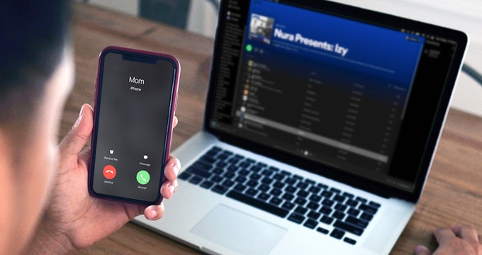 Someone receiving a call while playing music from their laptop