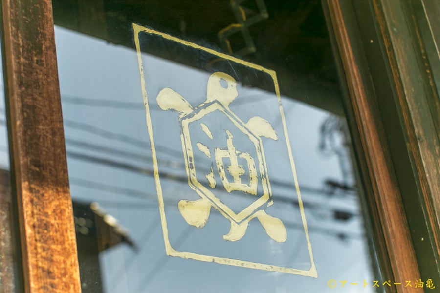 油亀の入口。ガラス戸に描かれたロゴマークが目印です。
