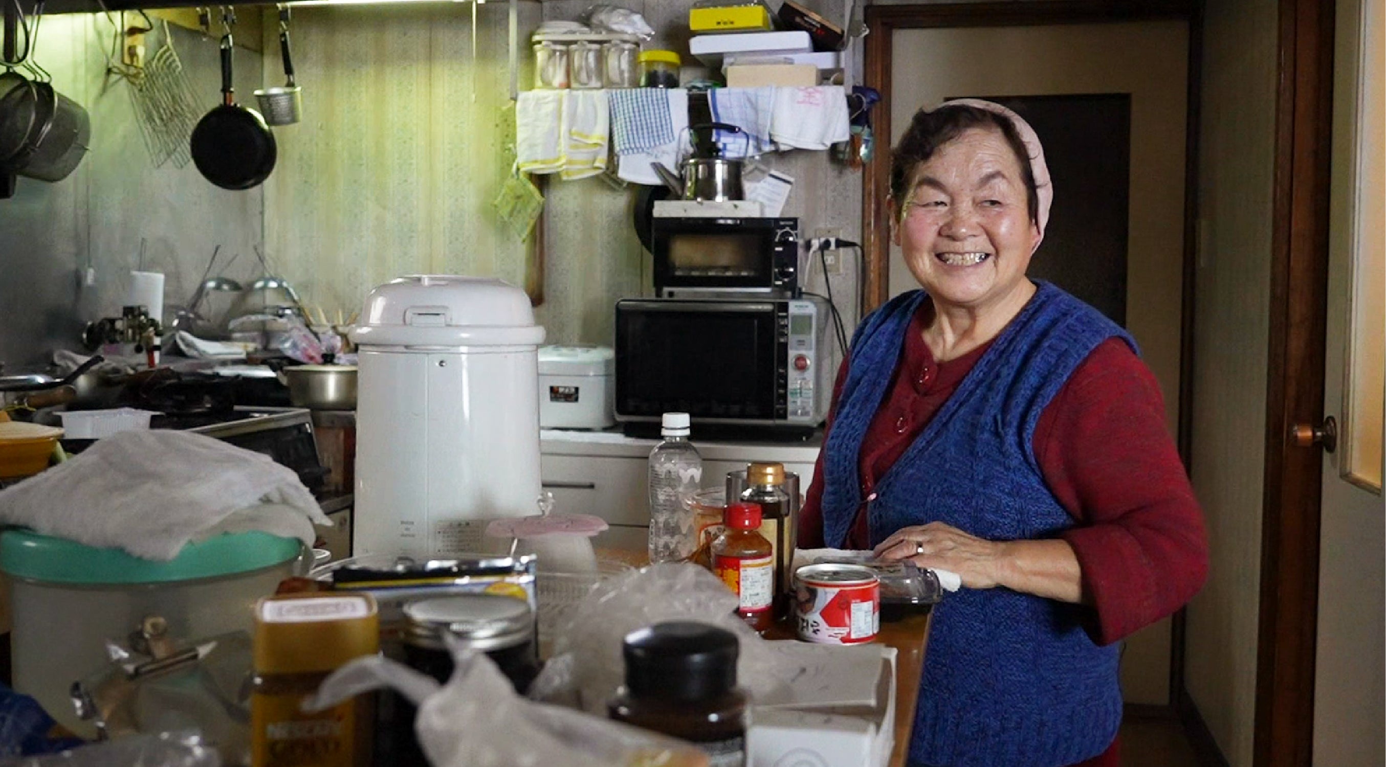 自宅の台所で笑顔のおばあちゃん